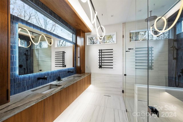 bathroom with vanity, a shower with shower door, and tile walls