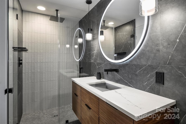 bathroom featuring vanity, an enclosed shower, and tile walls