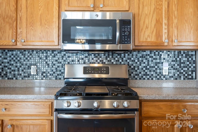 kitchen with backsplash and appliances with stainless steel finishes