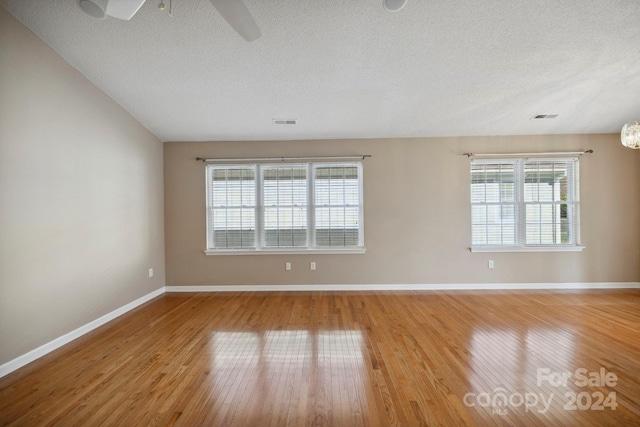 unfurnished room featuring ceiling fan, light hardwood / wood-style floors, and a textured ceiling