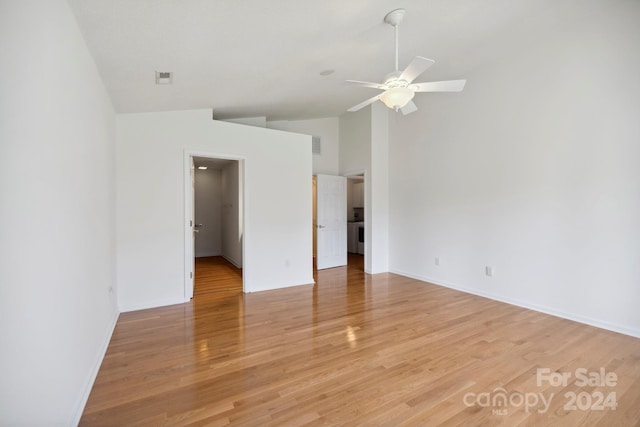 spare room with ceiling fan, vaulted ceiling, and light hardwood / wood-style flooring