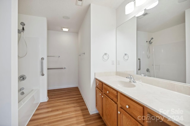 bathroom featuring shower / bath combination, a textured ceiling, vanity, and hardwood / wood-style flooring