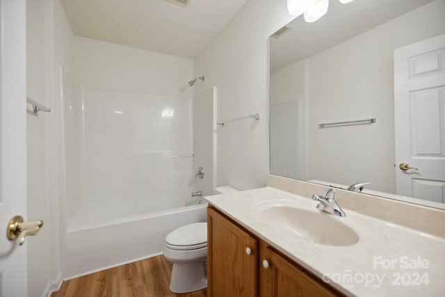 full bathroom with vanity, bathing tub / shower combination, hardwood / wood-style flooring, toilet, and a textured ceiling