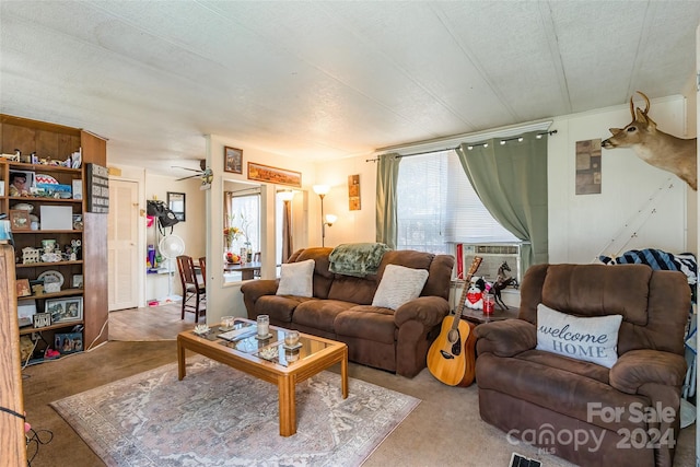 living room with ceiling fan, cooling unit, and a textured ceiling