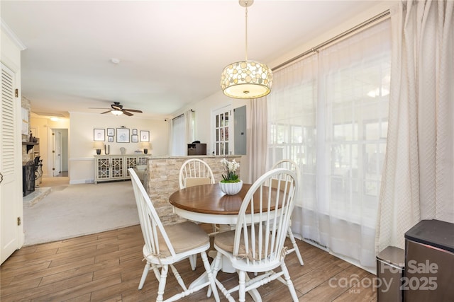 5431 Park Rd, Charlotte, NC 28209 - dining room with wood finished floors, a ceiling fan, and a fireplace with raised hearth