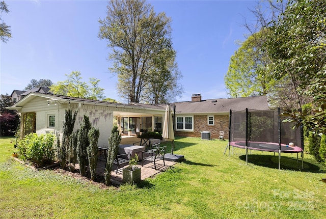 5431 Park Rd, Charlotte, NC 28209 - back of house with central air condition unit, a lawn, a patio, brick siding, and a trampoline