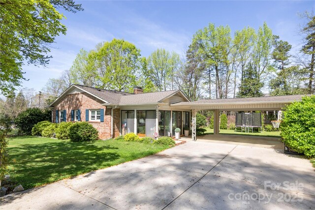 5431 Park Rd, Charlotte, NC 28209 - ranch-style house with a carport, a front yard, brick siding, a chimney, and driveway
