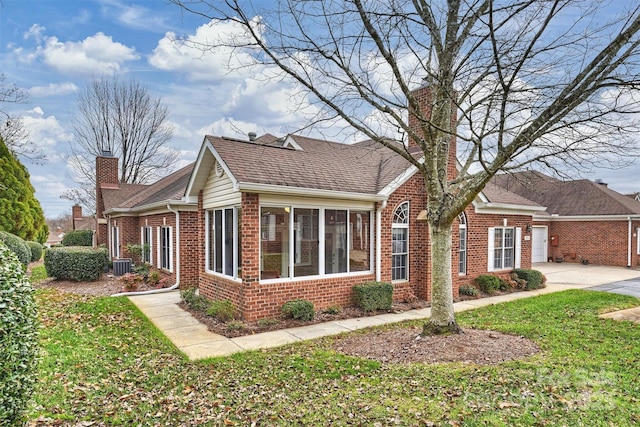 view of front facade with a front yard and central AC