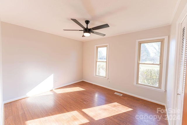 unfurnished room featuring hardwood / wood-style floors, plenty of natural light, and ceiling fan