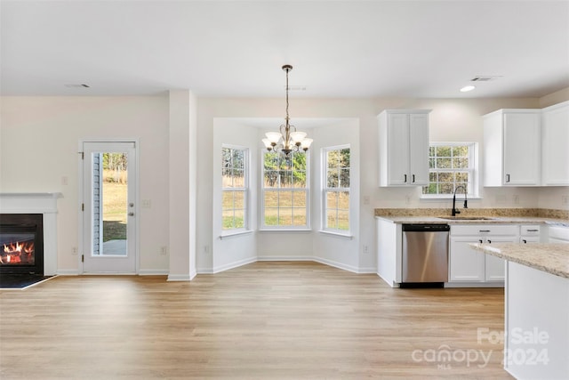 kitchen with a healthy amount of sunlight, white cabinets, stainless steel dishwasher, and light hardwood / wood-style floors