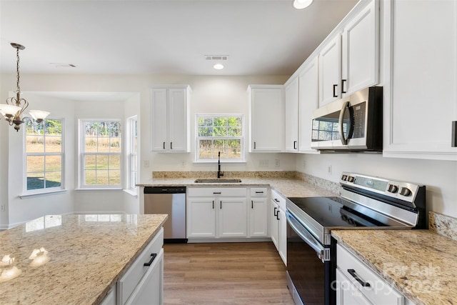 1805 Lexington Ave, Monroe, NC 28112 - kitchen with appliances with stainless steel finishes, a sink, light wood-style flooring, white cabinets, and a chandelier