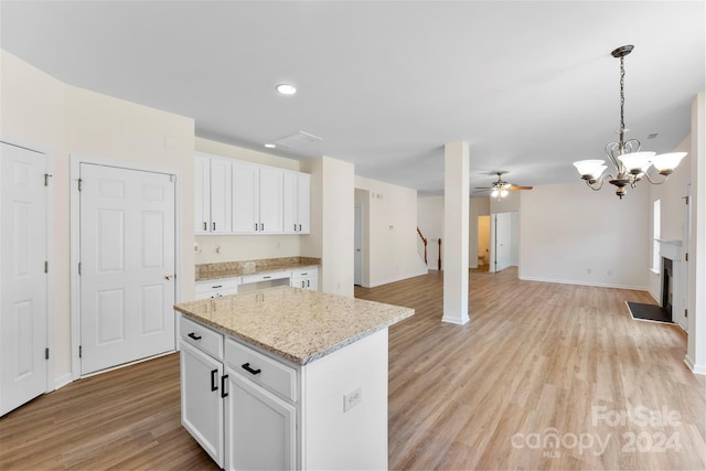 1805 Lexington Ave, Monroe, NC 28112 - kitchen featuring open floor plan, white cabinets, light wood-type flooring, a center island, and decorative light fixtures