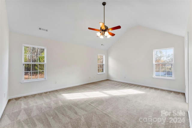 unfurnished room with light carpet, a healthy amount of sunlight, and vaulted ceiling