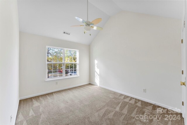 carpeted empty room featuring vaulted ceiling and ceiling fan