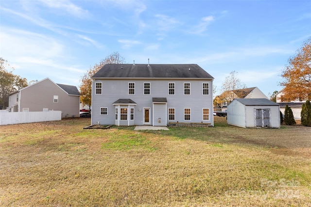 back of house featuring a patio, a storage shed, and a lawn