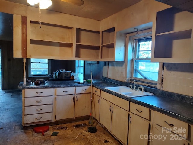 kitchen with decorative backsplash, kitchen peninsula, and sink