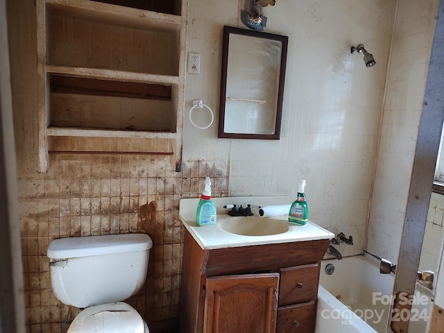 bathroom with vanity, toilet, and a bath