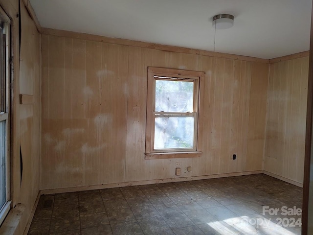 unfurnished room with wood walls