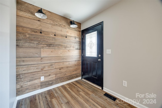 foyer with wooden walls and hardwood / wood-style floors