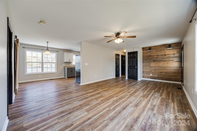 unfurnished living room featuring light hardwood / wood-style flooring and ceiling fan