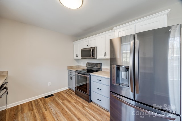 kitchen featuring light wood-type flooring, white cabinetry, and appliances with stainless steel finishes