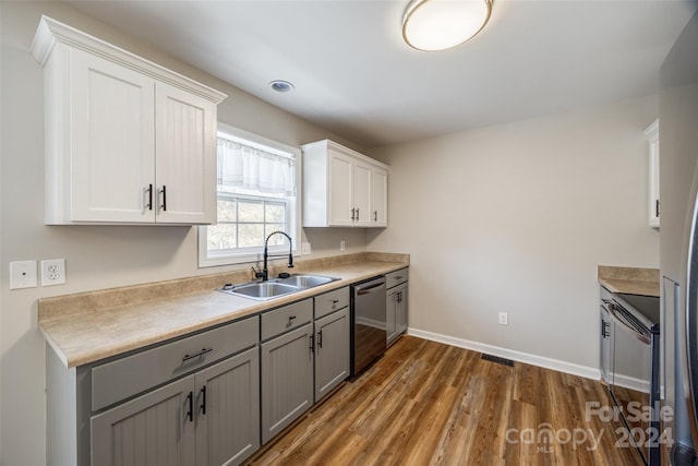 kitchen with dark wood-type flooring, sink, gray cabinets, appliances with stainless steel finishes, and white cabinetry