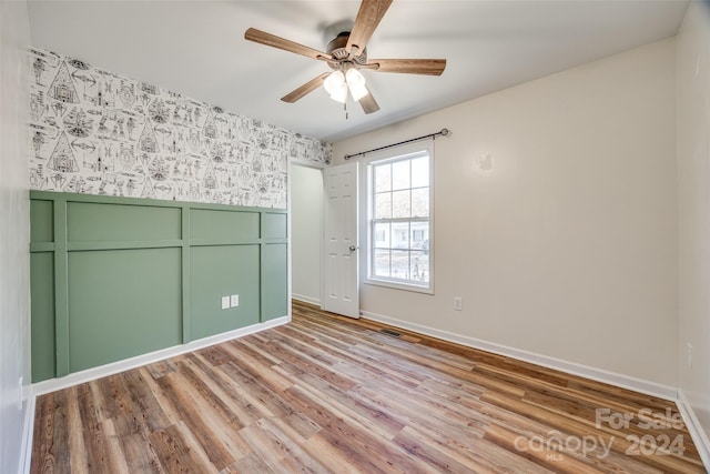 empty room with light hardwood / wood-style floors and ceiling fan