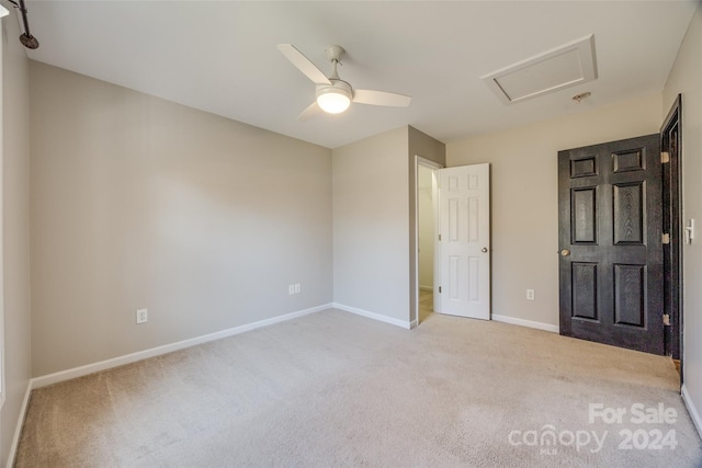 empty room featuring ceiling fan and light colored carpet