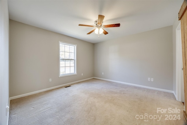 carpeted spare room with ceiling fan