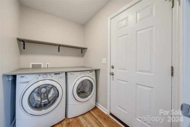 laundry room featuring washer and dryer and light wood-type flooring