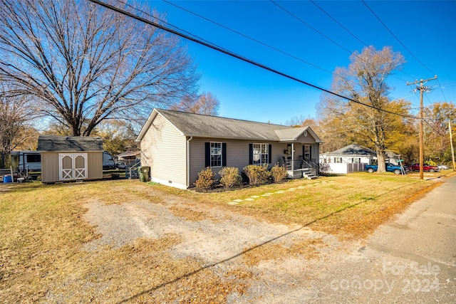 view of front of property with covered porch, a front lawn, and a storage unit