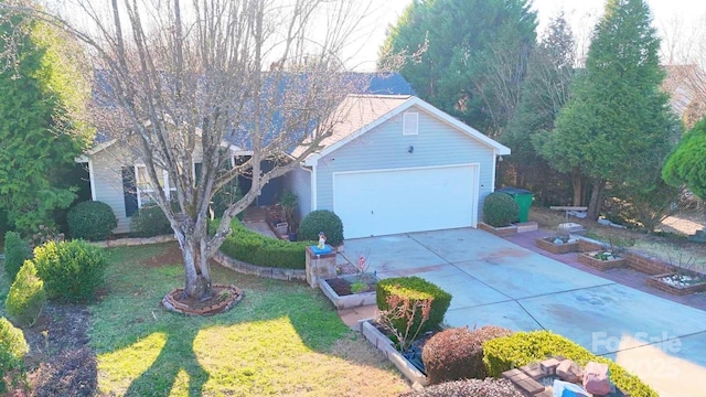 view of front of house featuring a garage, a vegetable garden, and a front yard