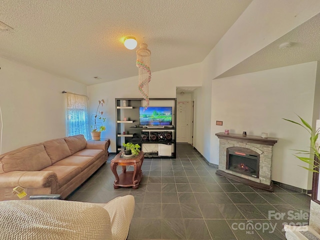 8430 Stoneman Pl, Charlotte, NC 28217 - living area featuring vaulted ceiling, dark tile patterned flooring, a stone fireplace, and a textured ceiling