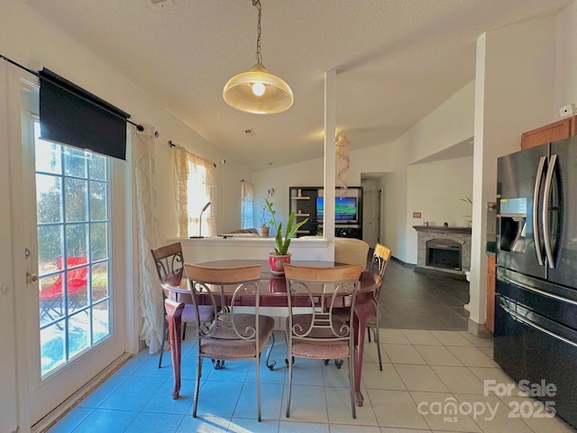 8430 Stoneman Pl, Charlotte, NC 28217 - tiled dining room featuring lofted ceiling, a textured ceiling, and a fireplace