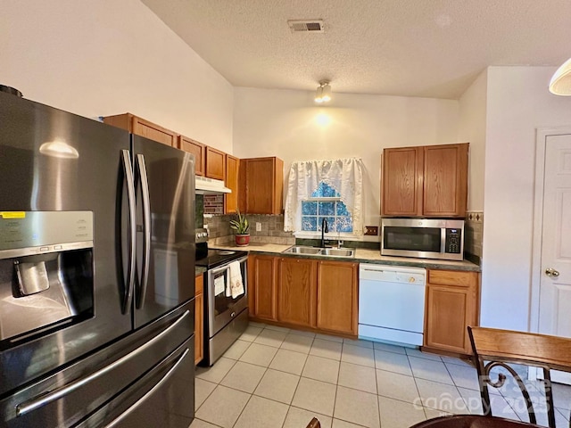 8430 Stoneman Pl, Charlotte, NC 28217 - kitchen featuring under cabinet range hood, a sink, visible vents, appliances with stainless steel finishes, and brown cabinets