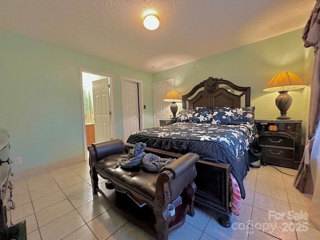 8430 Stoneman Pl, Charlotte, NC 28217 - bedroom featuring connected bathroom, a textured ceiling, baseboards, and light tile patterned floors