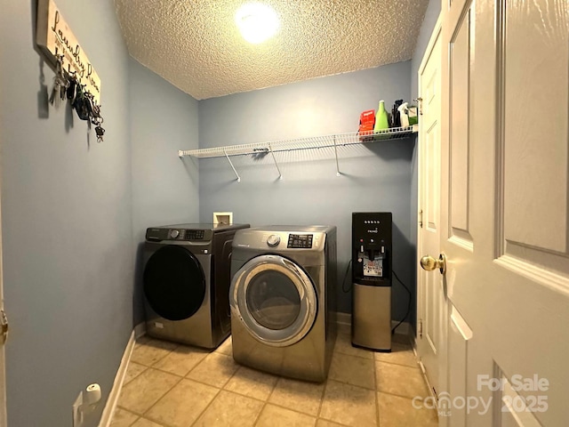 8430 Stoneman Pl, Charlotte, NC 28217 - laundry area with laundry area, baseboards, washing machine and clothes dryer, a textured ceiling, and light tile patterned flooring