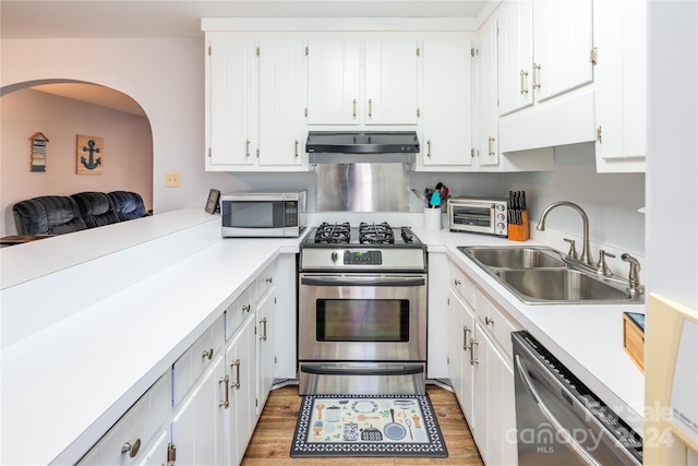 kitchen with white cabinetry, sink, stainless steel appliances, and dark hardwood / wood-style floors