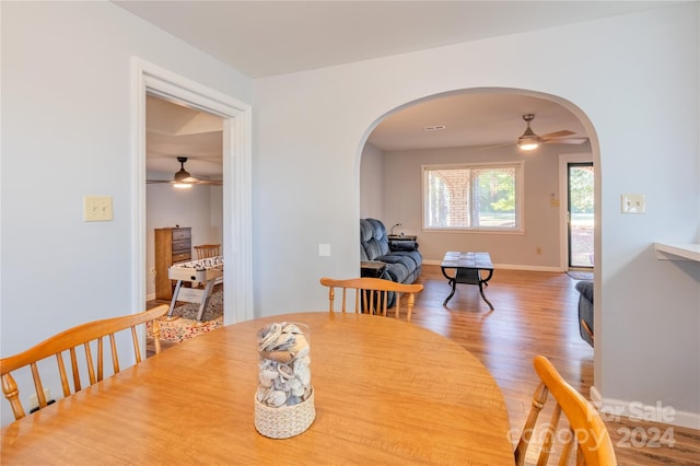 dining area featuring wood-type flooring and ceiling fan