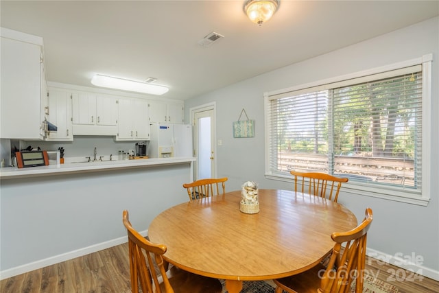 dining space with hardwood / wood-style floors and sink