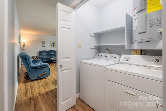 washroom with independent washer and dryer, hardwood / wood-style flooring, and water heater