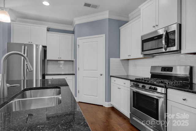 kitchen featuring white cabinetry, appliances with stainless steel finishes, sink, and hanging light fixtures