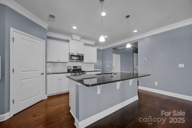 kitchen featuring sink, appliances with stainless steel finishes, hanging light fixtures, an island with sink, and white cabinets