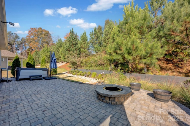 view of patio / terrace with a fire pit and a hot tub