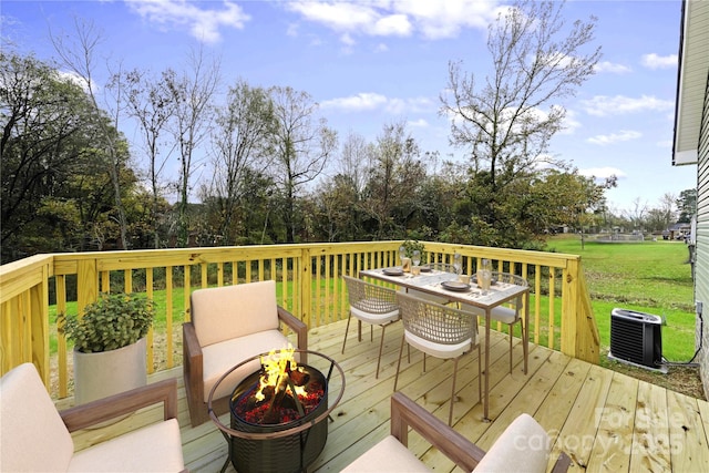 deck with cooling unit, a fire pit, and a lawn