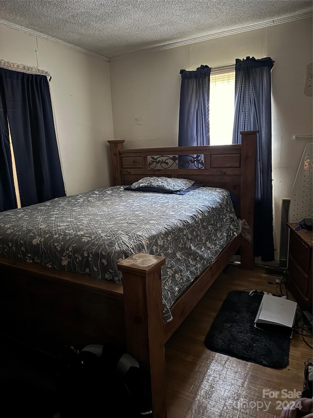 bedroom with a textured ceiling and hardwood / wood-style flooring