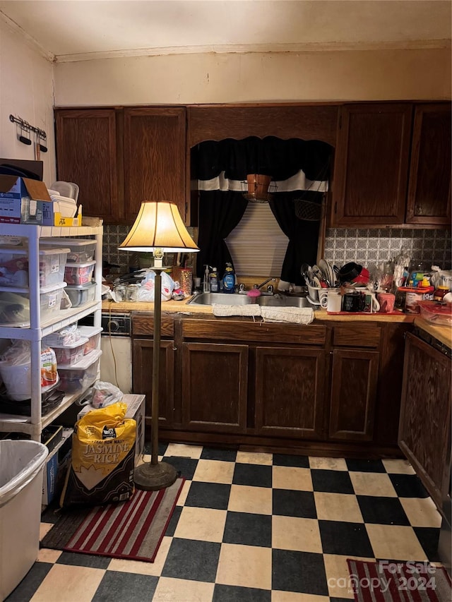 kitchen featuring dark brown cabinetry, tasteful backsplash, and sink