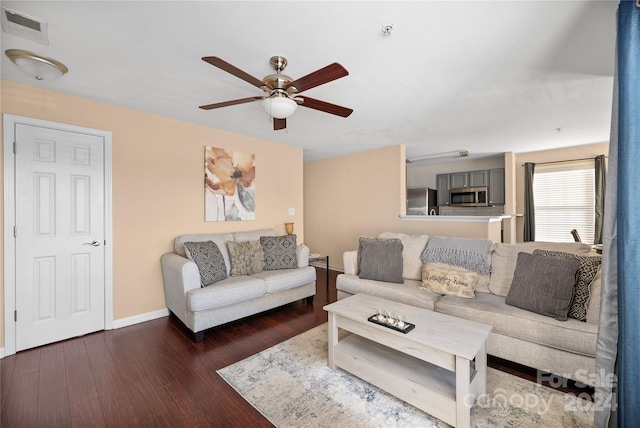 living room featuring ceiling fan and dark wood-type flooring