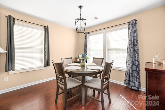 dining room with dark hardwood / wood-style flooring and an inviting chandelier