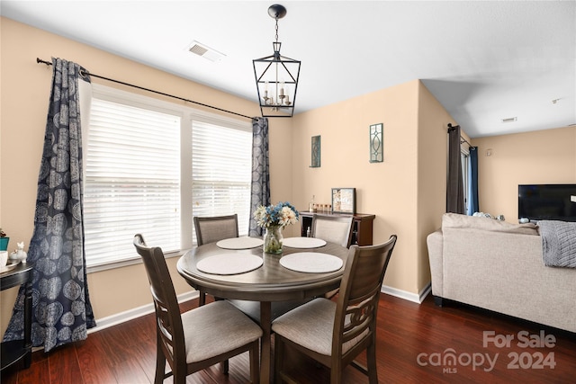 dining area featuring dark hardwood / wood-style floors and an inviting chandelier